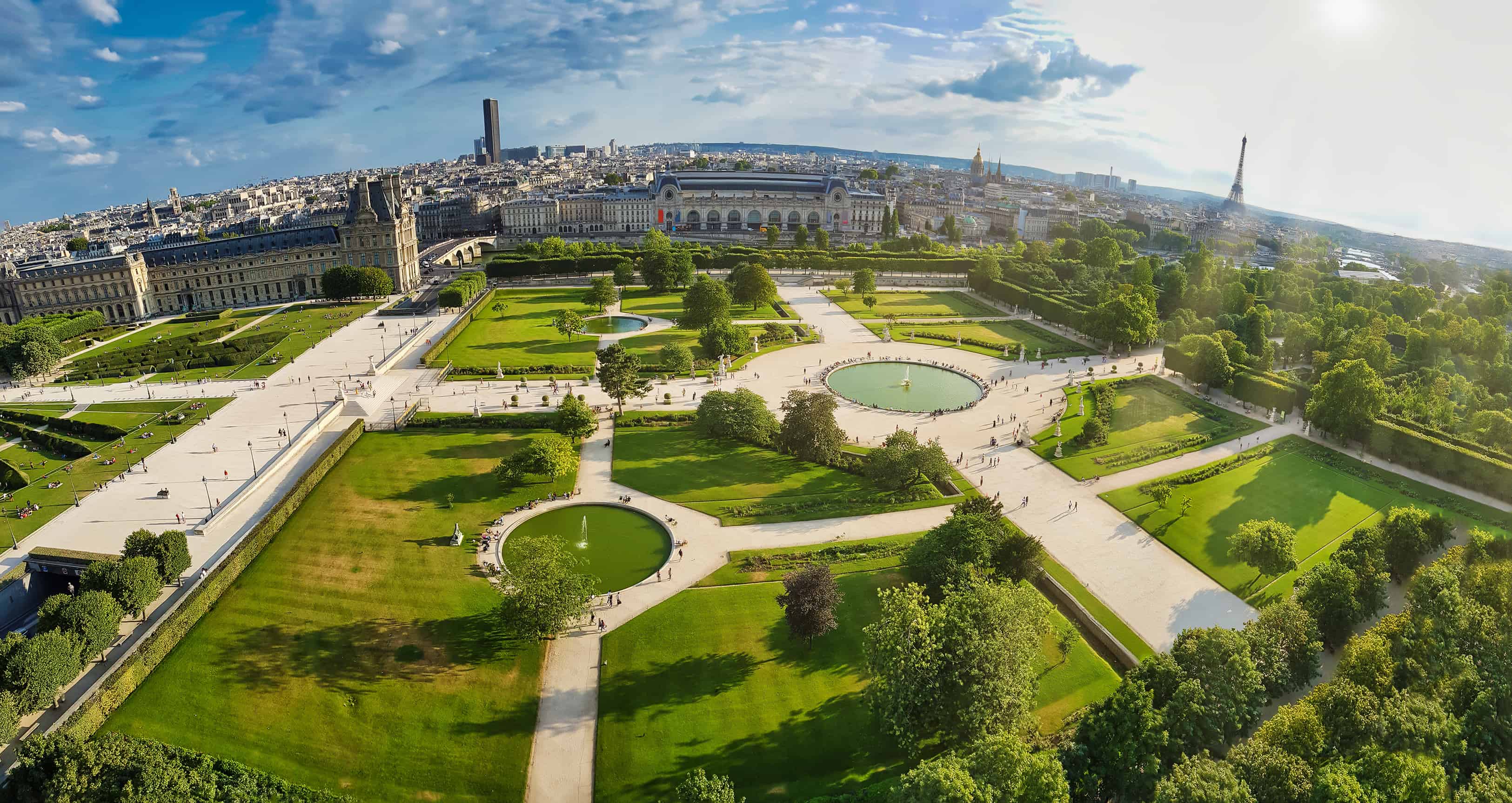 High-angle skyline showing the famous Jardin des Tuileries park of Paris, with the tower of Eiffel in the far horizon.
