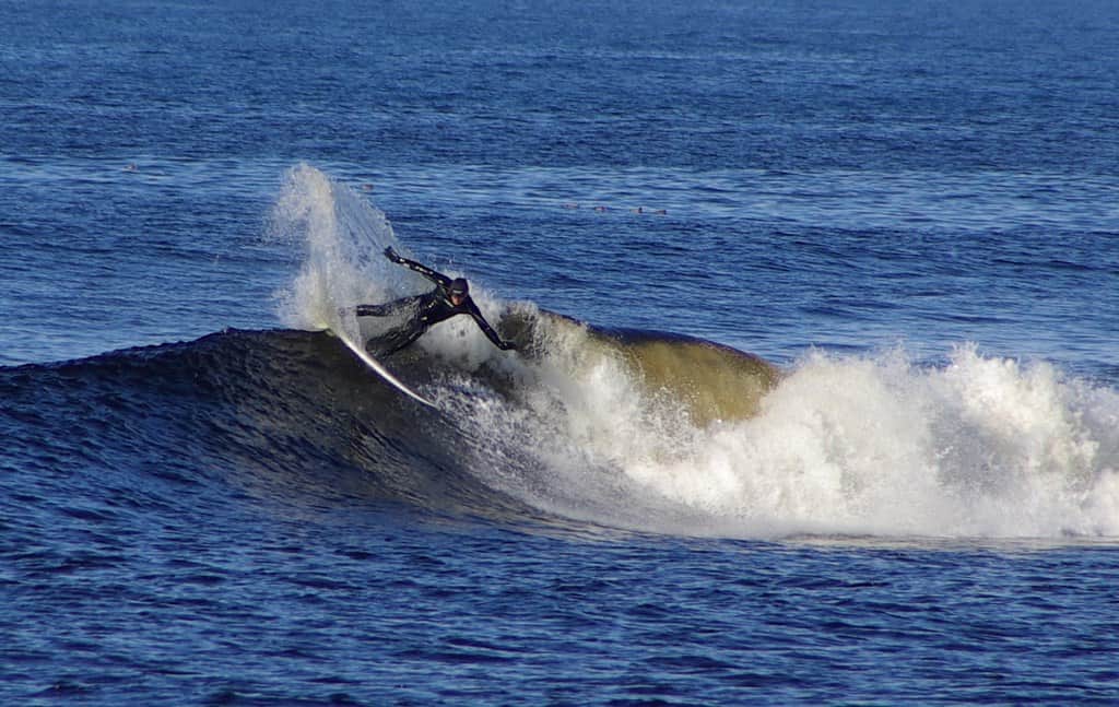 A surfer catches a wave at Thurso East