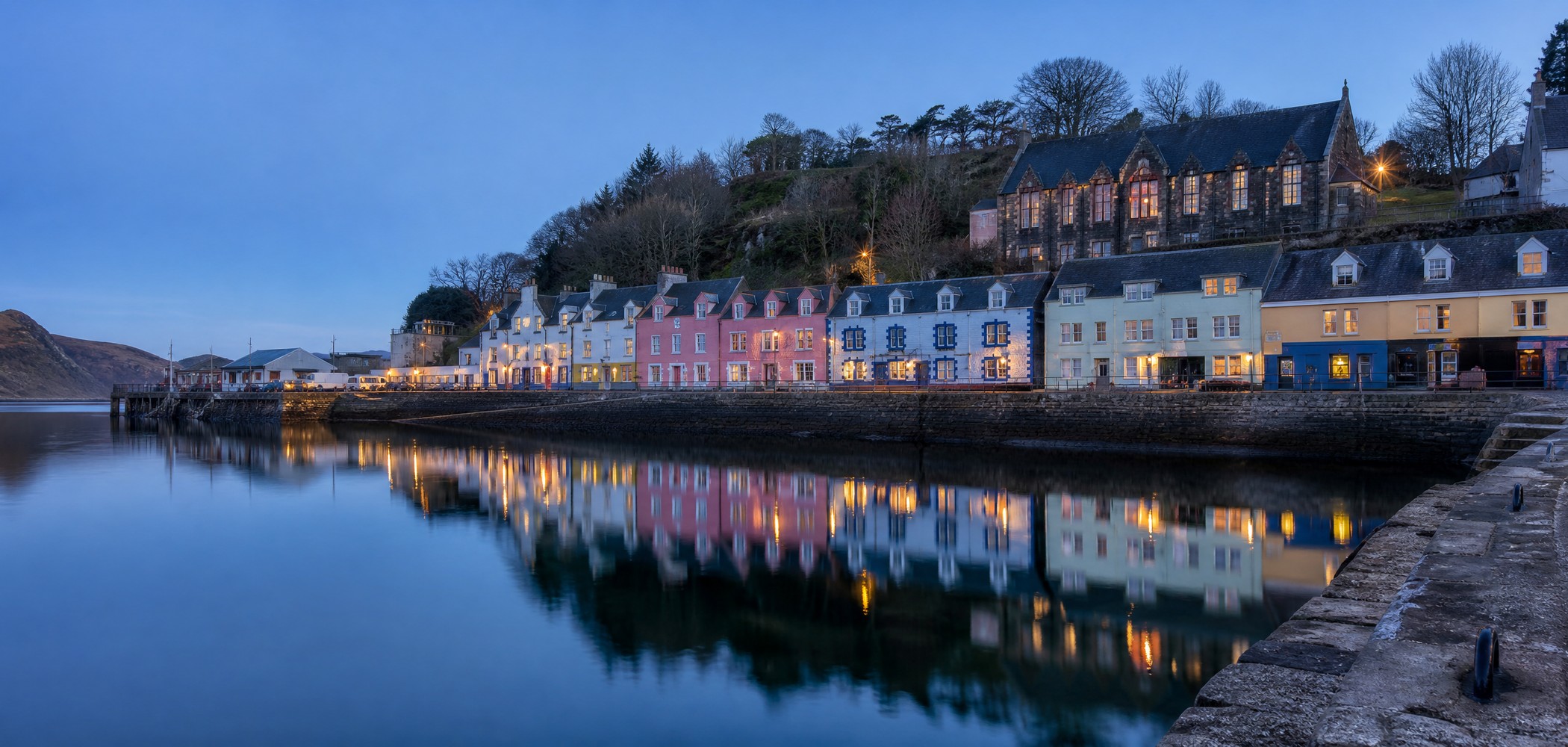 Colourful waterfront buildings reflected in quiet Tobermory Harbour on the Isle of Mull.