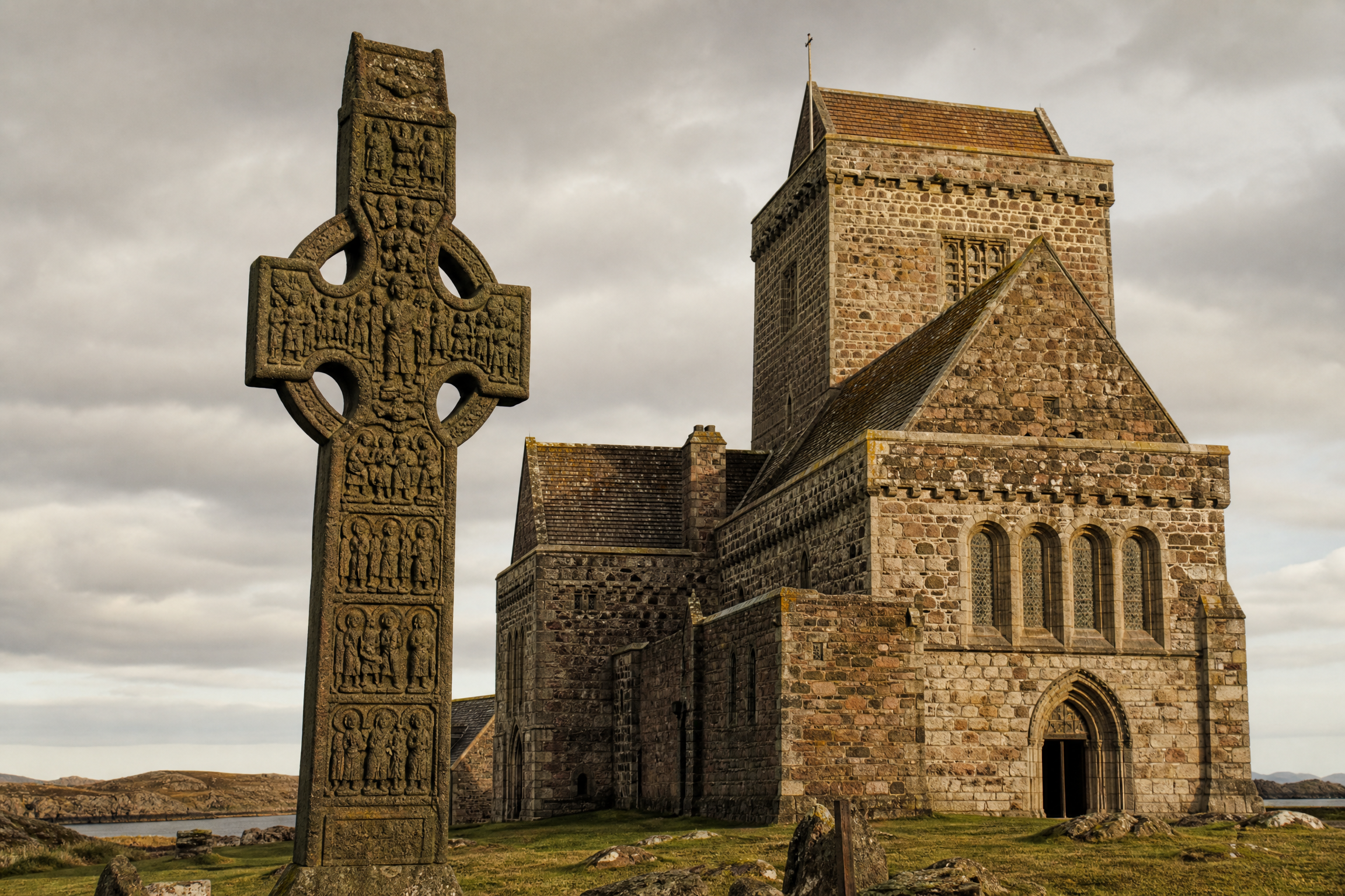Iona Abbey restored church exterior with a carved Celtic high cross, Isle of Iona, Scotland