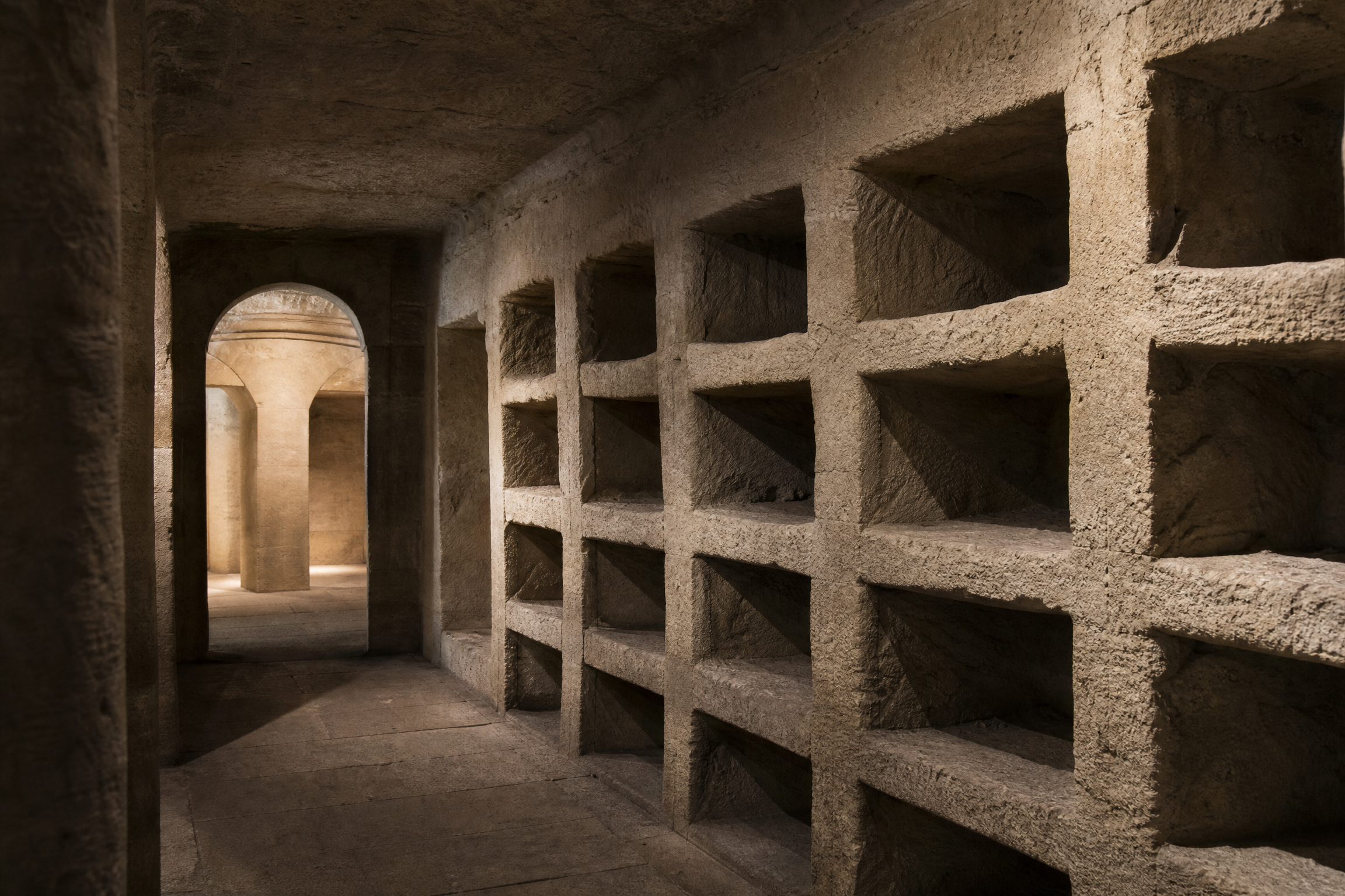 Quiet corridor lined with loculi burial niches in the Catacombs of Kom el Shoqafa, Alexandria
