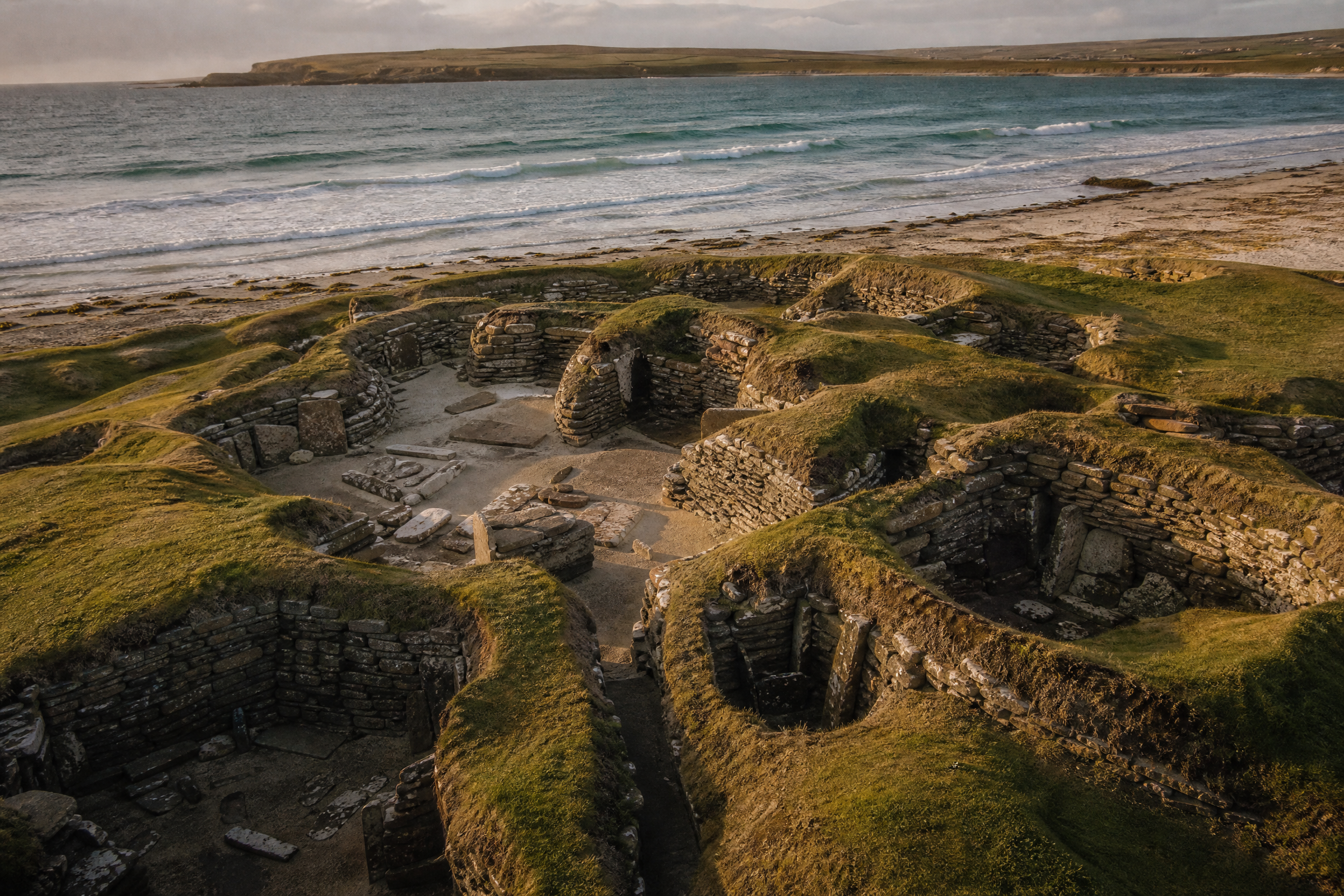 Aerial view of the Skara Brae excavation site with the Bay of Skaill and the Atlantic coast behind, Orkney