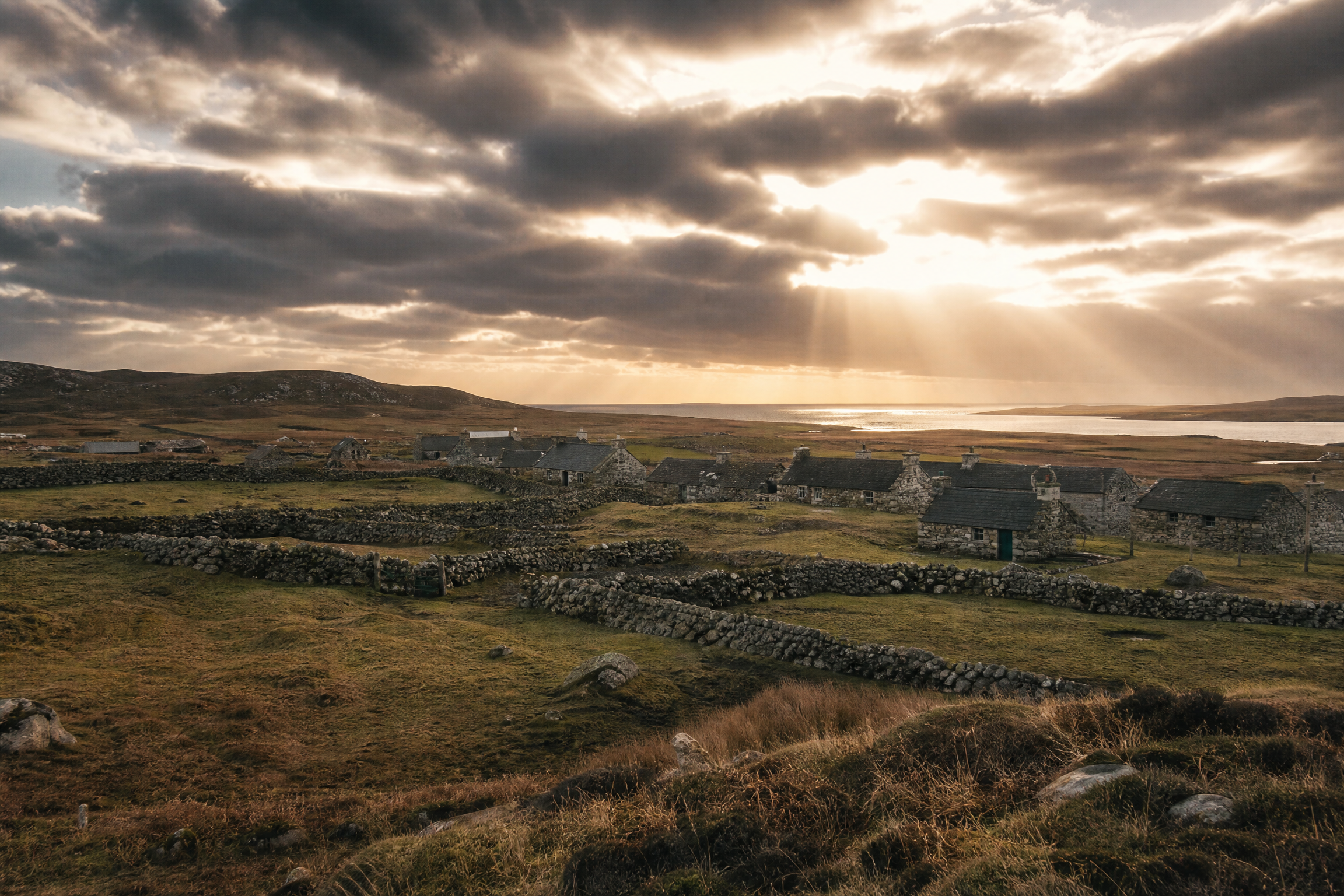 A Hebridean crofting township with stone-walled enclosures and stone buildings beside an Atlantic loch