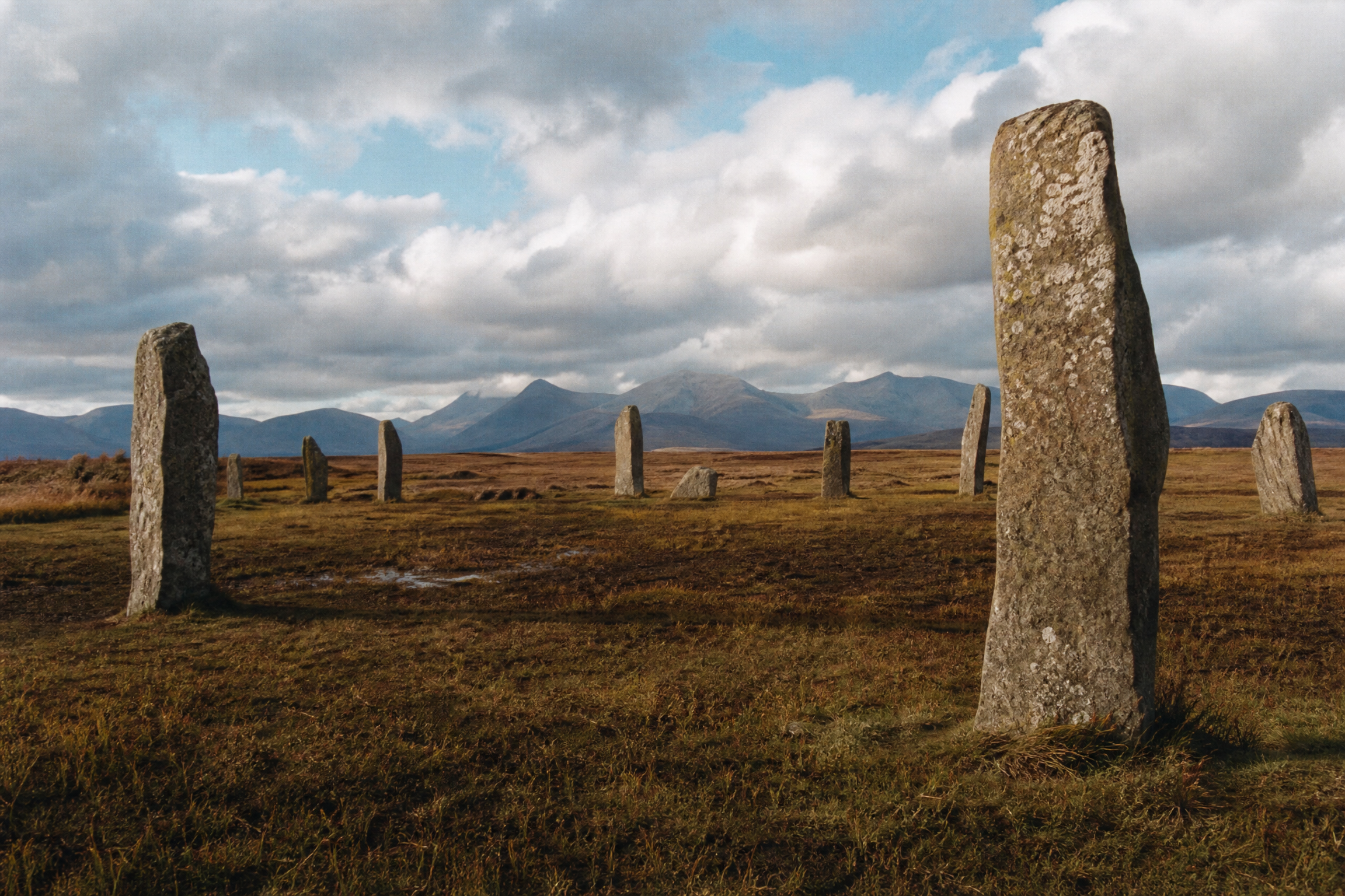 Standing stone circle across the wide moorland of Machrie Moor, Isle of Arran, with mountains on the horizon
