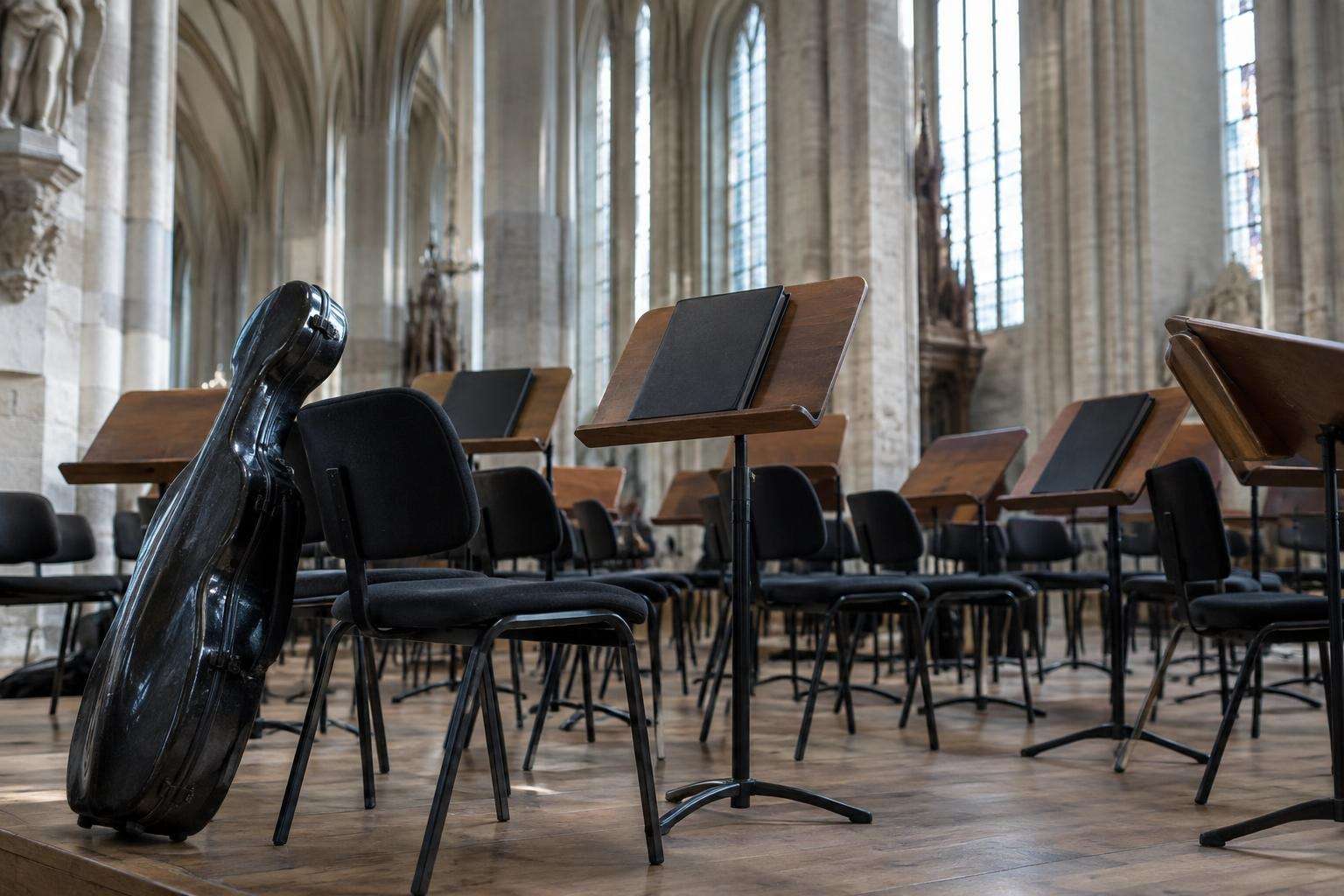 Rows of empty chairs and music stands set out before a concert beneath the vaulted ceiling of a Gothic church in Leipzig