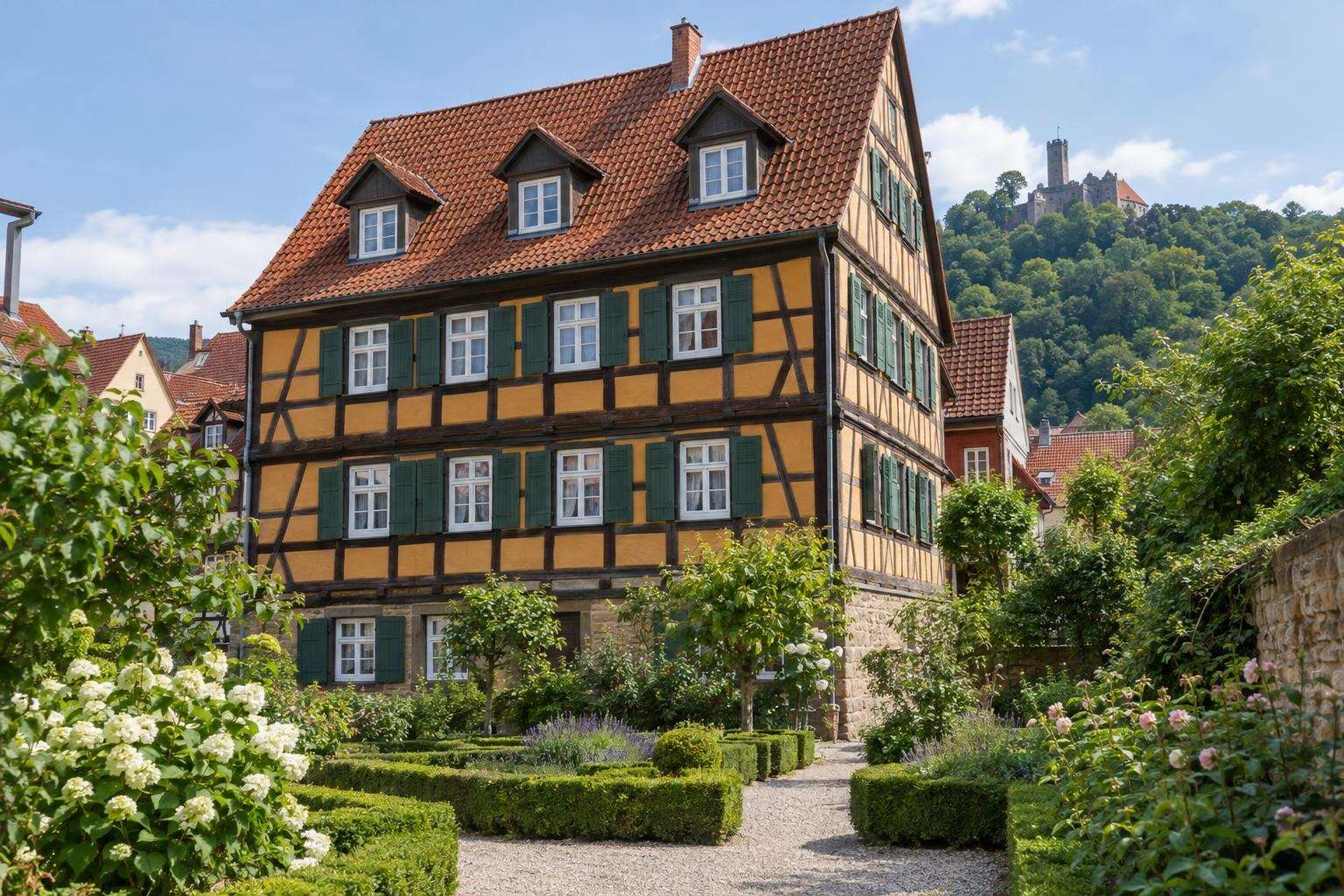 A half-timbered town house with ochre infill and a small Baroque garden in Eisenach, Thuringia, on a sunny morning