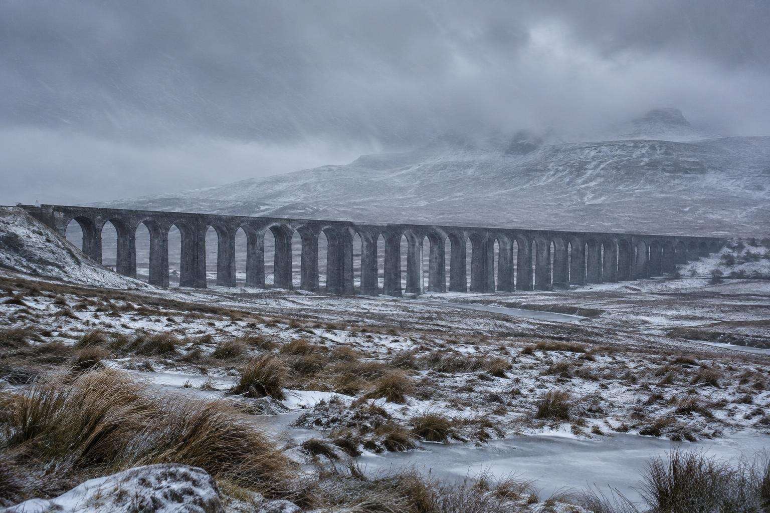 The Ribblehead Viaduct on snow-covered Batty Moss in the Yorkshire Dales under low winter cloud, showing how exposed the site is