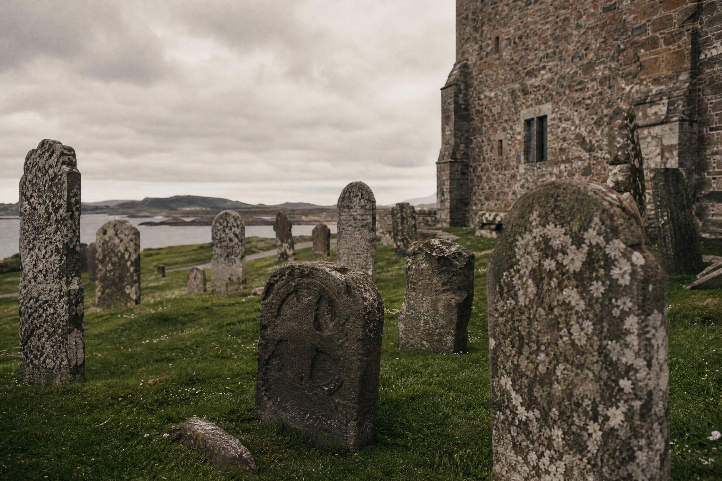 Weathered medieval gravestones at Reilig Odhrain graveyard beside Iona Abbey, Scotland